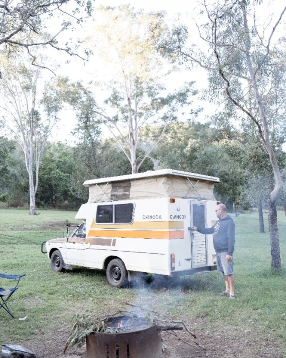 Dave and the Chinook camped in the Australian bush, pop-top up beside a campfire
